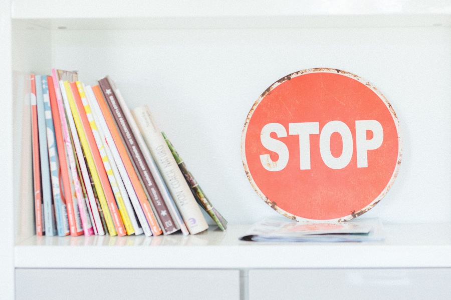 SEO Irrtümer Federfuhrwerk Blogartikel: Symbolbild Stopschild auf Bücherregal